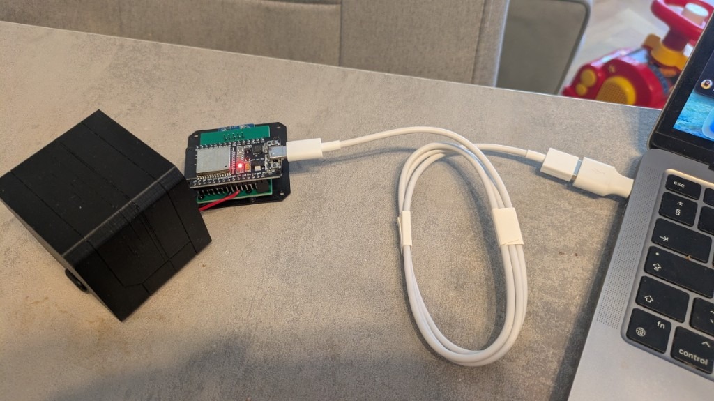 ESP32 on the bench — USB to laptop, enclosure shell beside the board